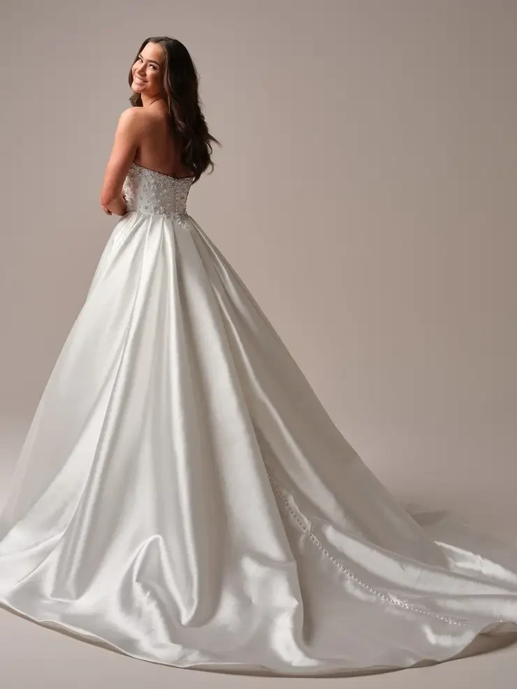 model is wearing a strapless ball gown wedding dress by maggie sottero