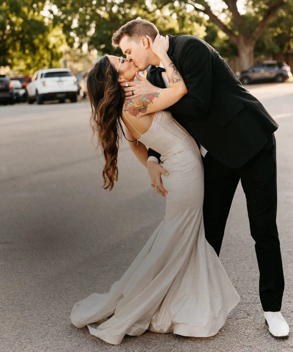 Сouple wearing a white gown and a black suit. Mobile image