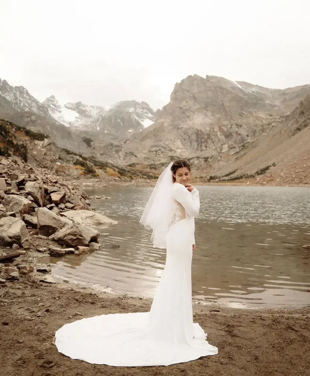 image shows bride facing back at the camera wearing her wedding dress with a long train